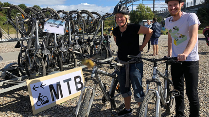 Trailer med mountainbikes og to personer foran